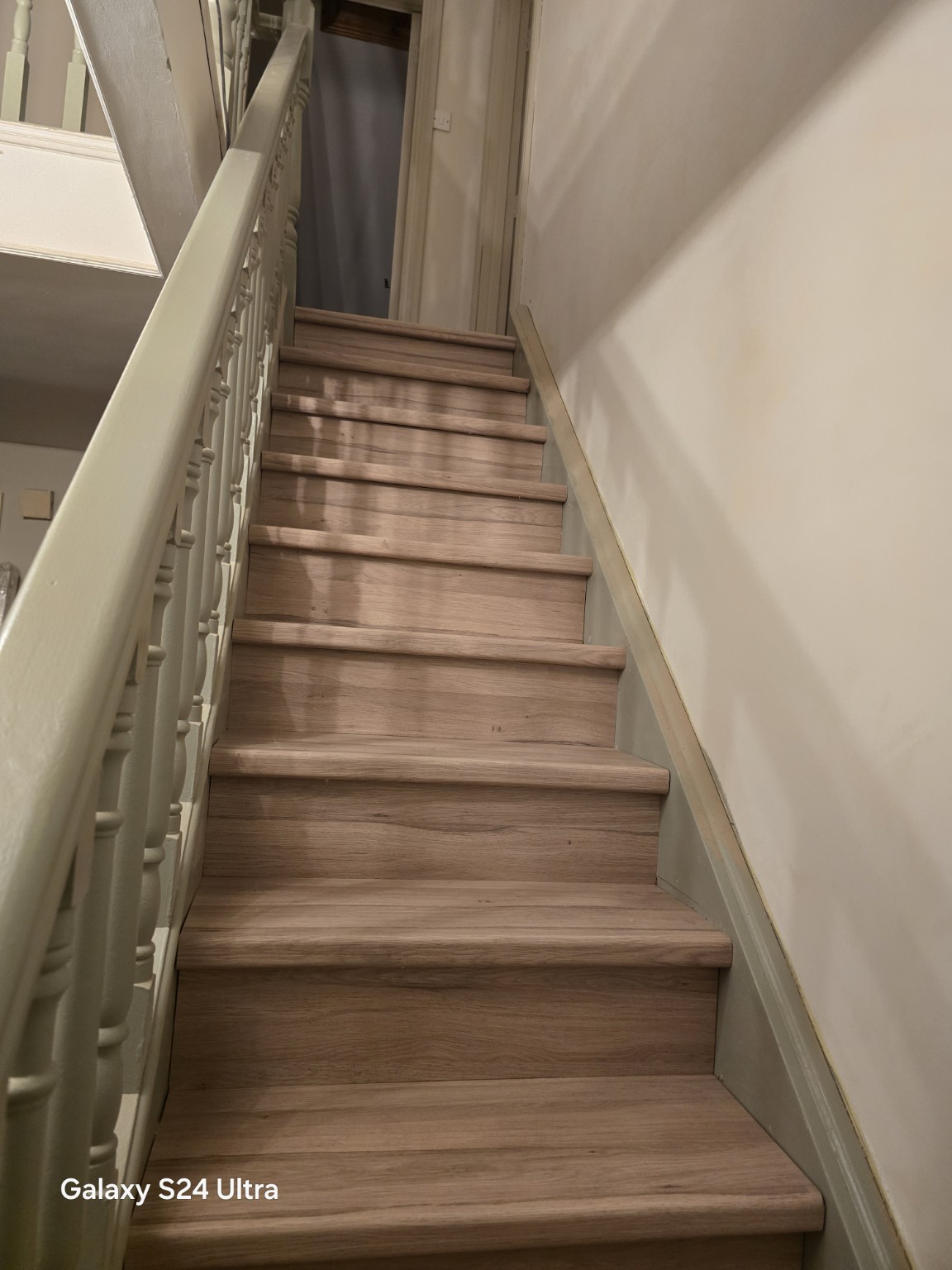 Renovated staircase with wood-effect treads and painted balustrade